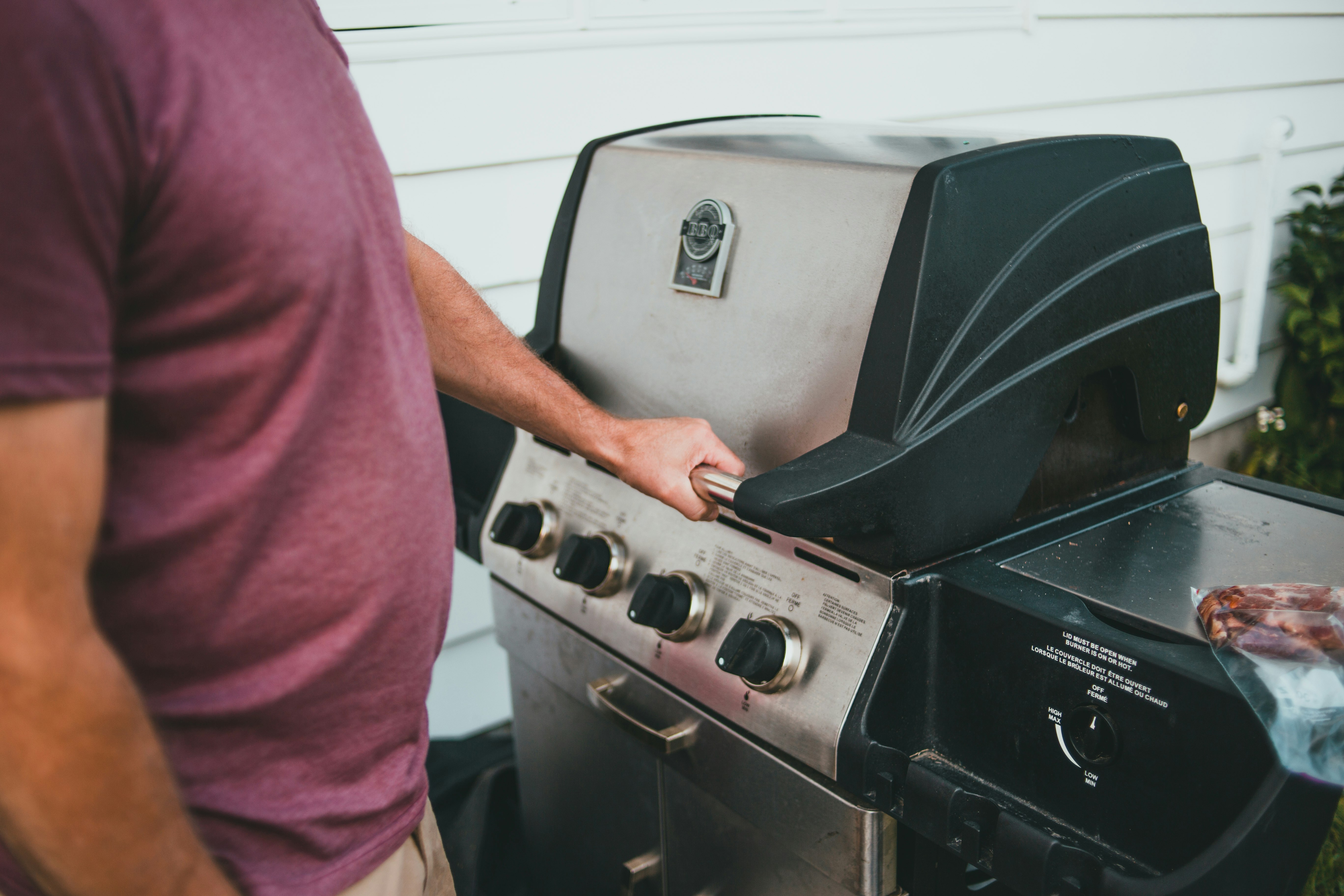 person in red t-shirt standing in front of gas range oven
