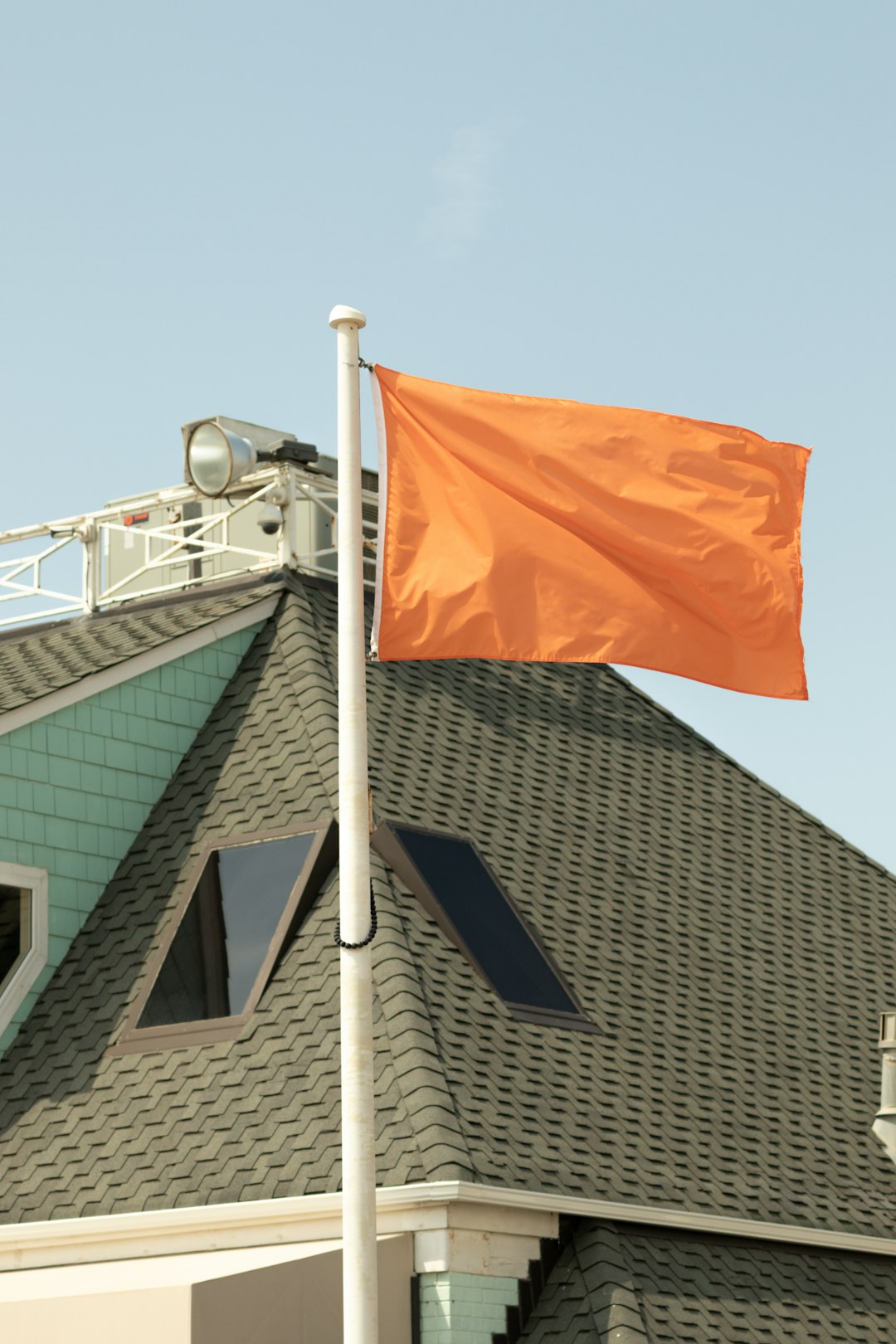 orange and white flag on top of building