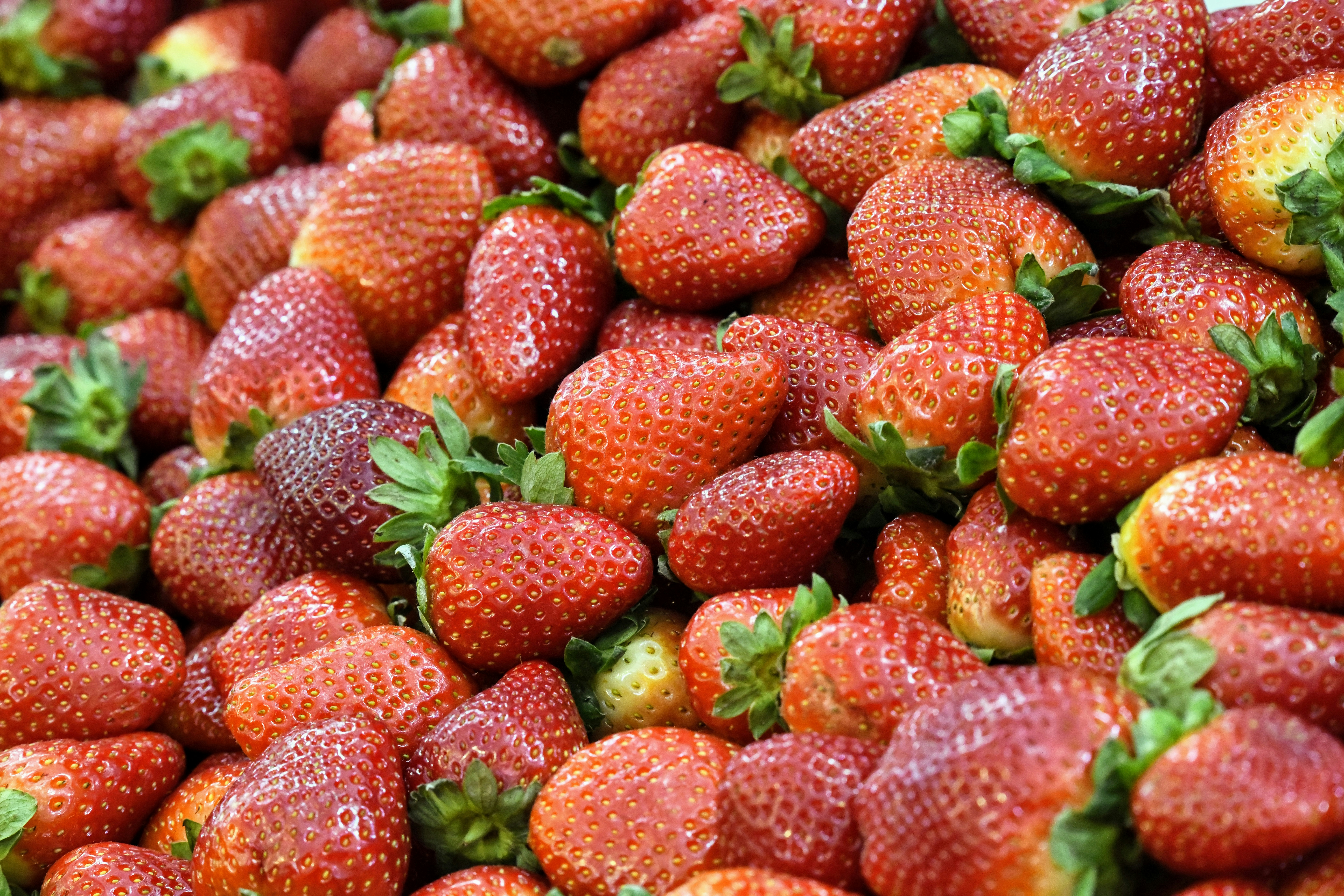 red strawberries on green leaves