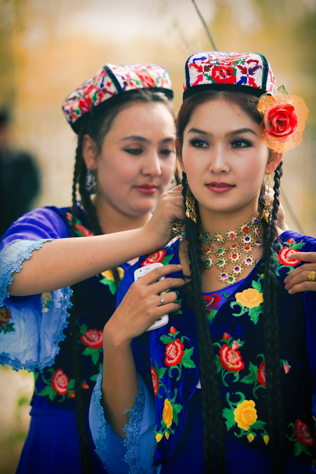 woman in blue and white floral dress beside woman in blue and white floral dress