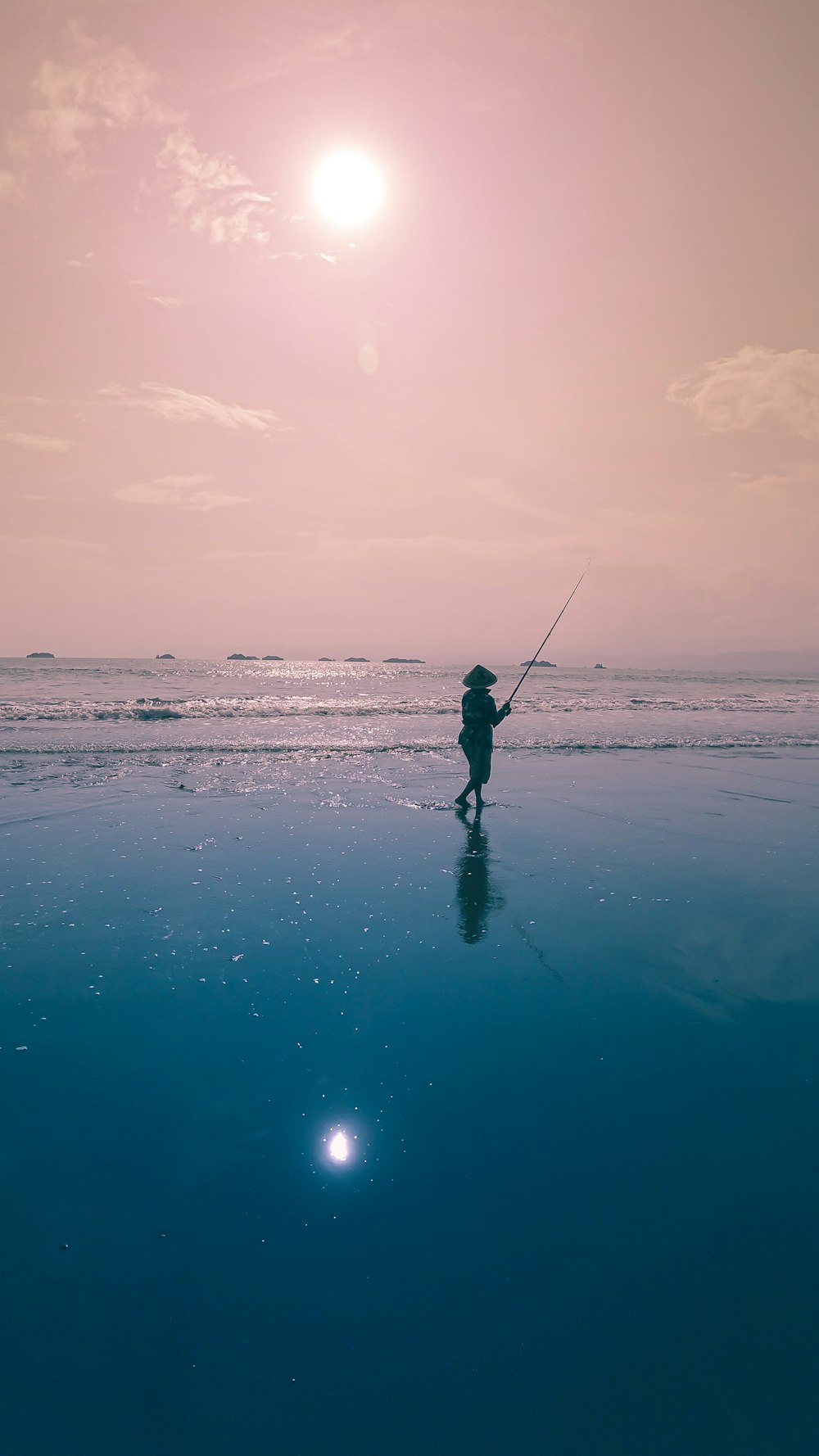 person in black jacket and pants standing on seashore during daytime