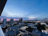 A city skyline featuring high-rise real estate buildings at sunset.