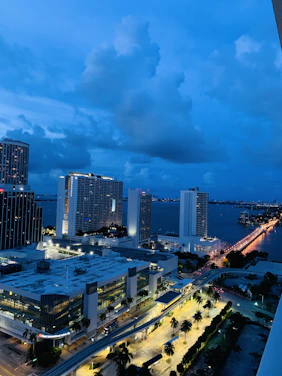 A sleek, futuristic cityscape of Monrovia at dusk, highlighting modern transportation and renewable energy infrastructure.