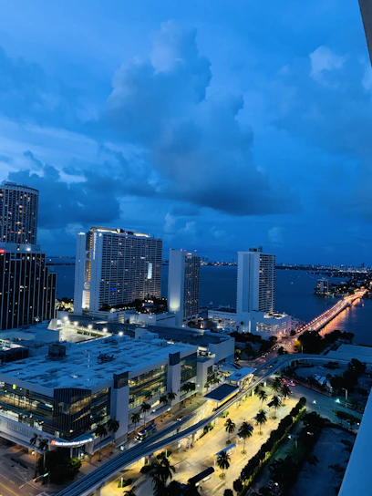 A sleek, futuristic cityscape of Monrovia at dusk, highlighting modern transportation and renewable energy infrastructure.