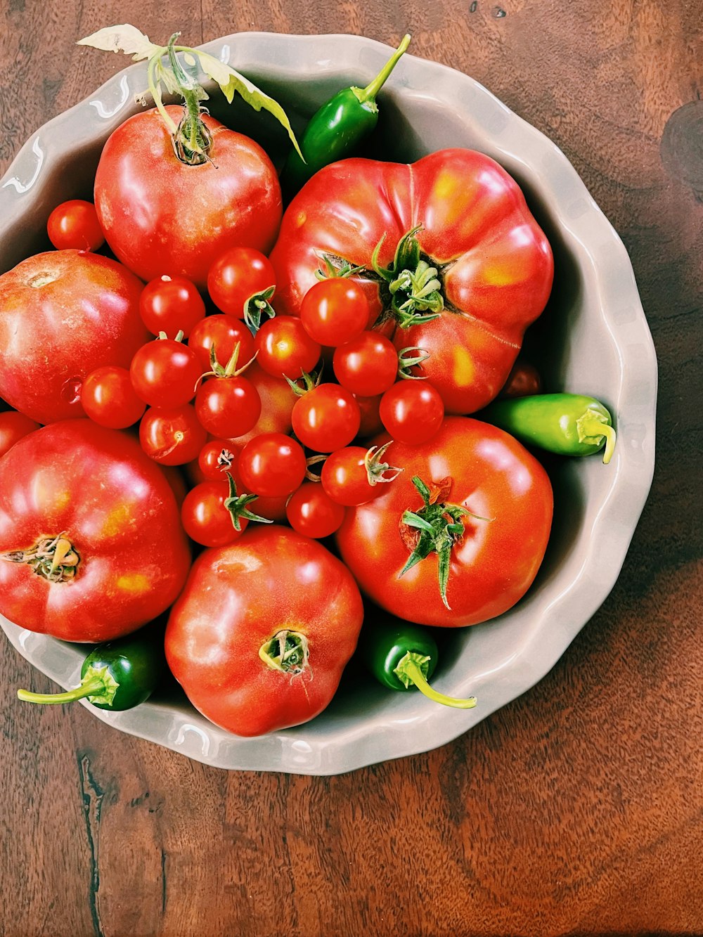 red tomatoes on white ceramic bowl