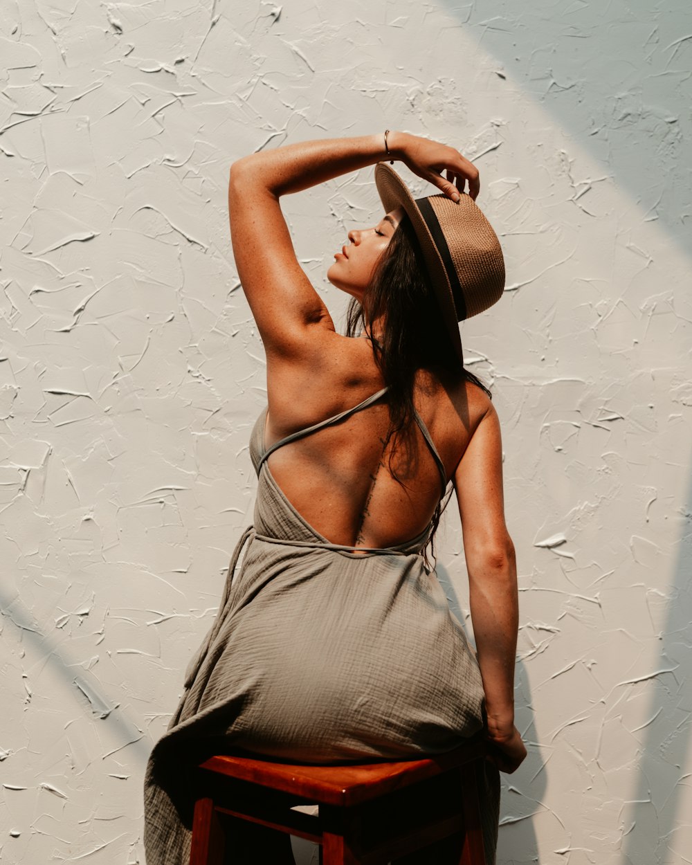 woman in gray spaghetti strap dress wearing brown sun hat