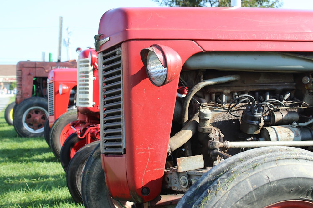 roter und schwarzer Traktor tagsüber auf grünem Rasen