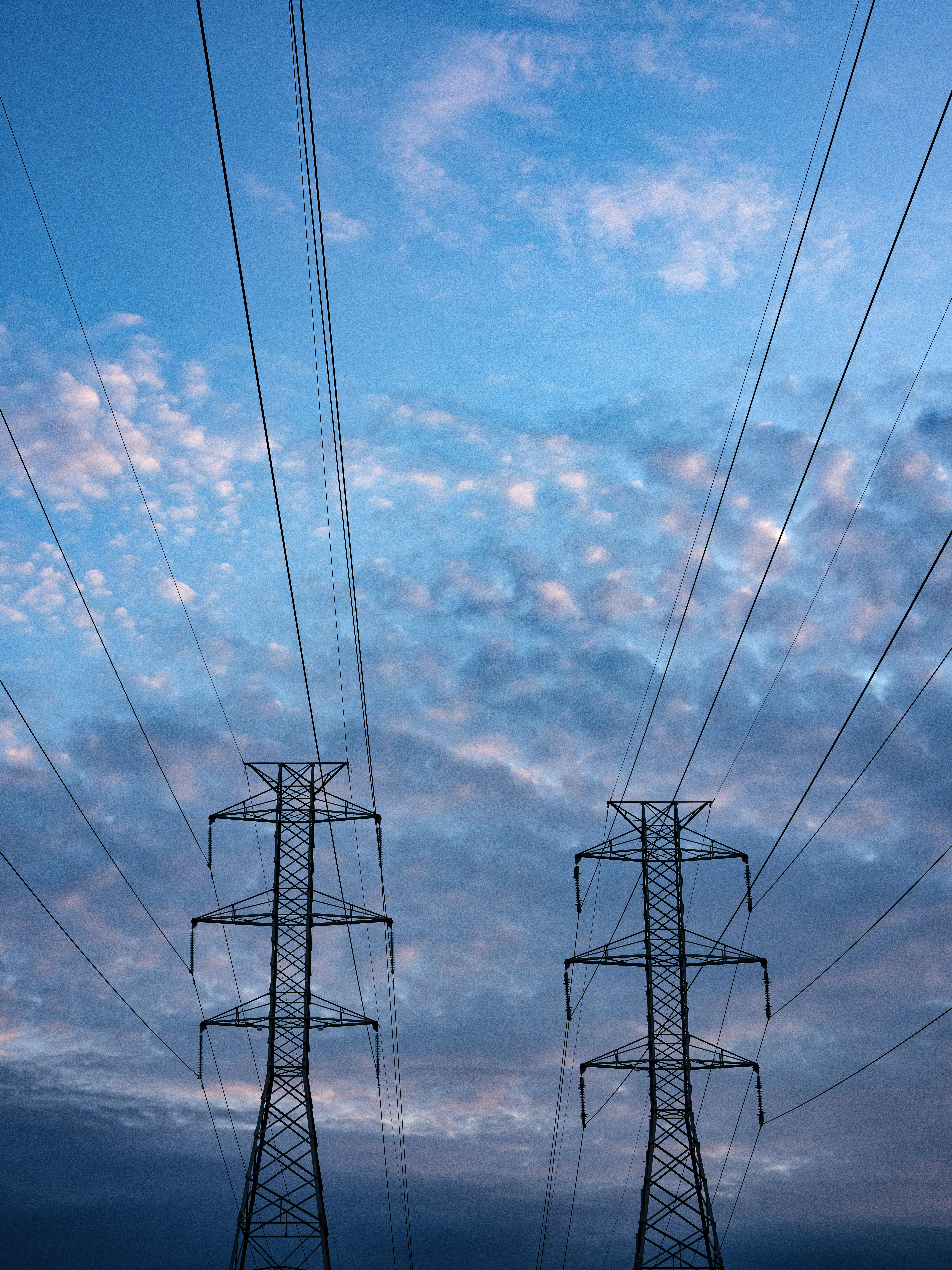 black electric tower under blue sky and white clouds during daytime