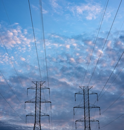 black electric tower under blue sky and white clouds during daytime