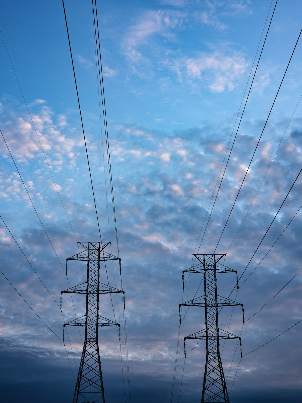 Torre elettrica nera sotto il cielo blu e le nuvole bianche durante il giorno