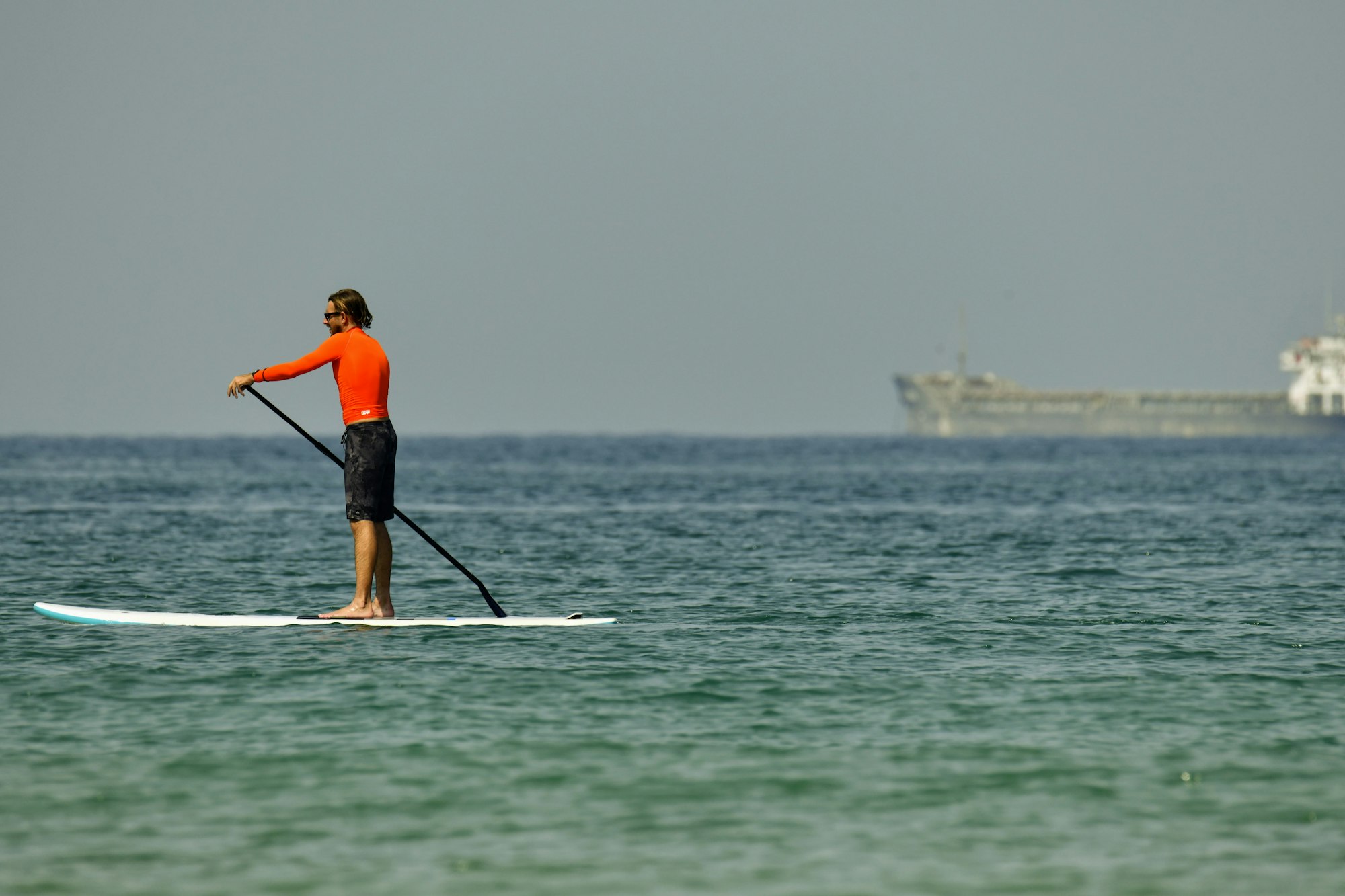 I captured this man on a surfboard paddling on the Mediterianean Sea on a hot summer morning next to the Port of Ashdod. 