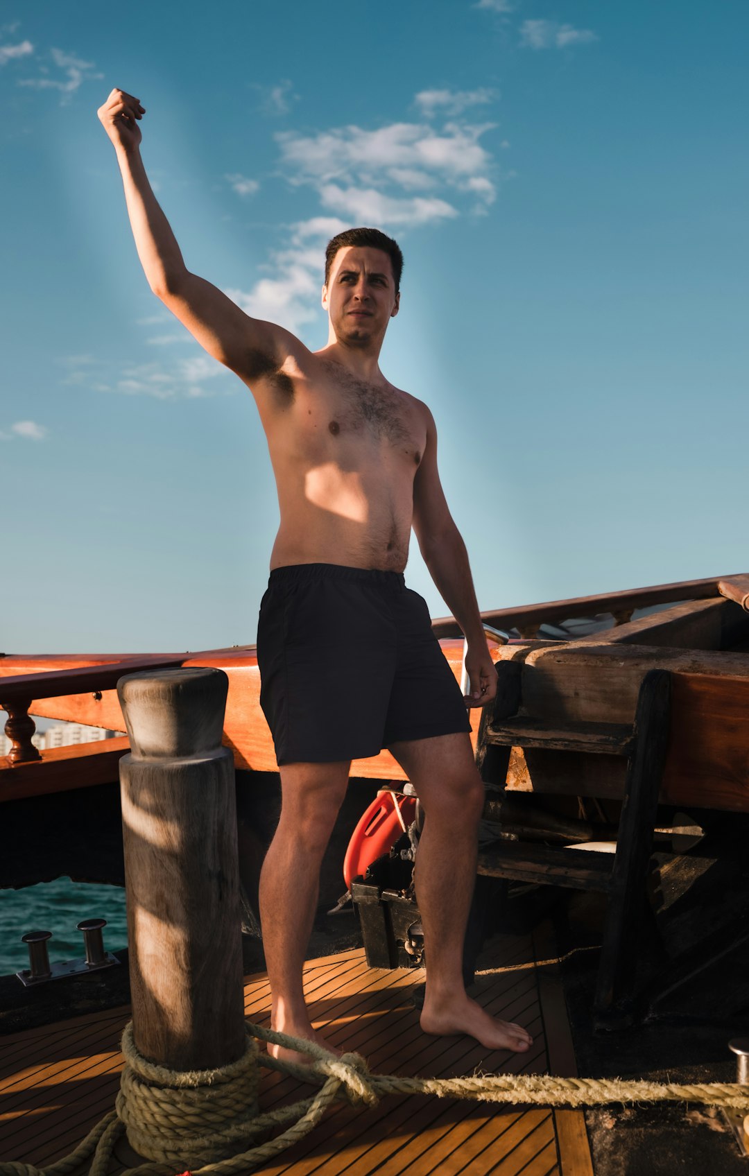 man in black shorts standing on brown wooden dock during daytime