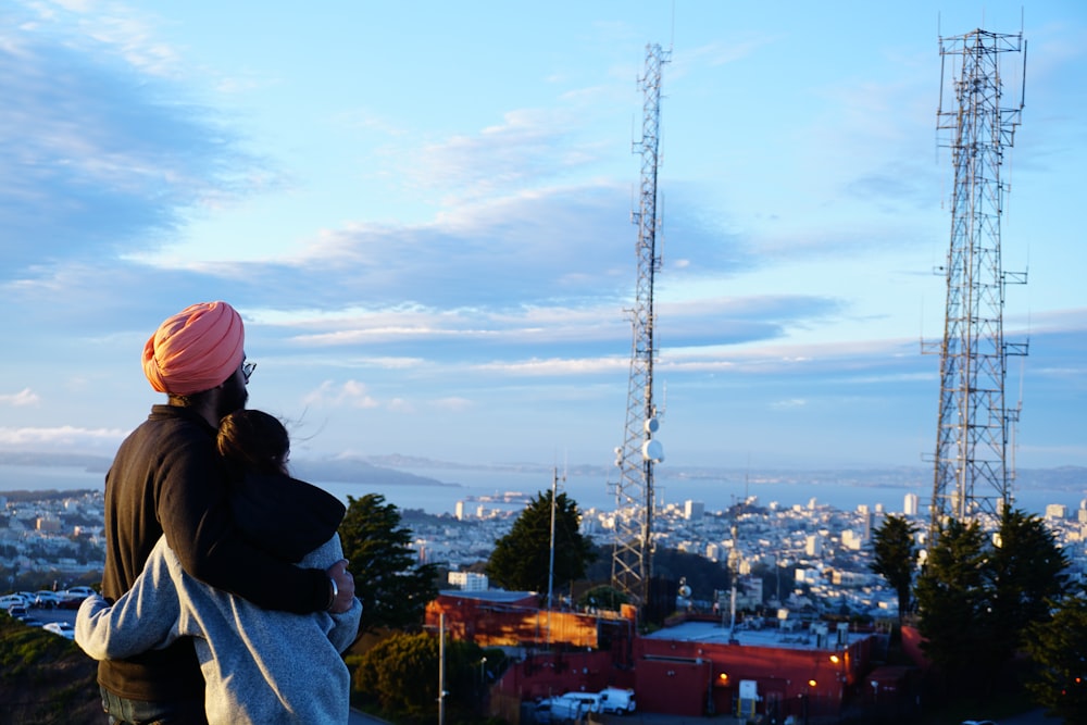 woman in black jacket and pink knit cap standing on top of building during daytime