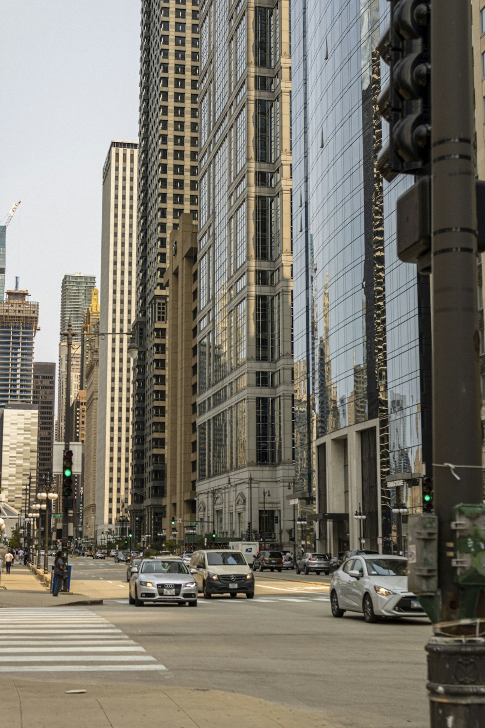 cars on road between high rise buildings during daytime