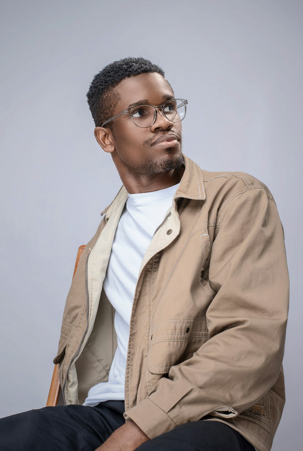 man in brown button up jacket wearing black framed eyeglasses