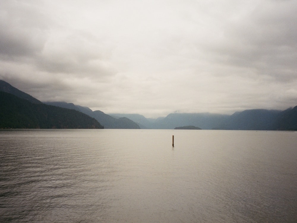 body of water near mountain during daytime