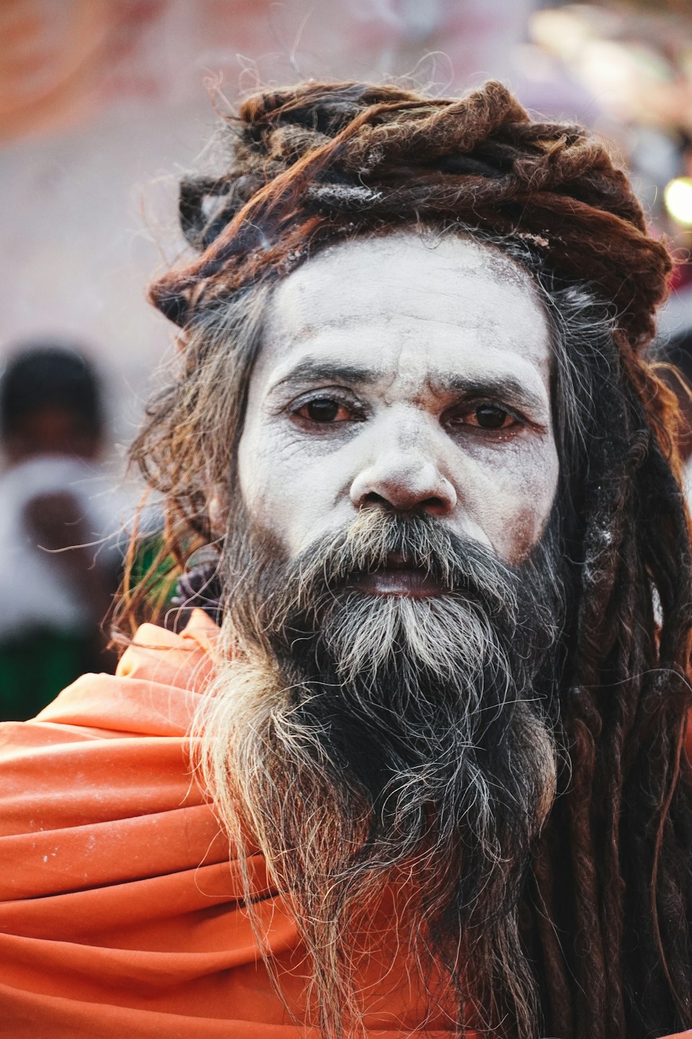 man in orange hoodie with white face paint