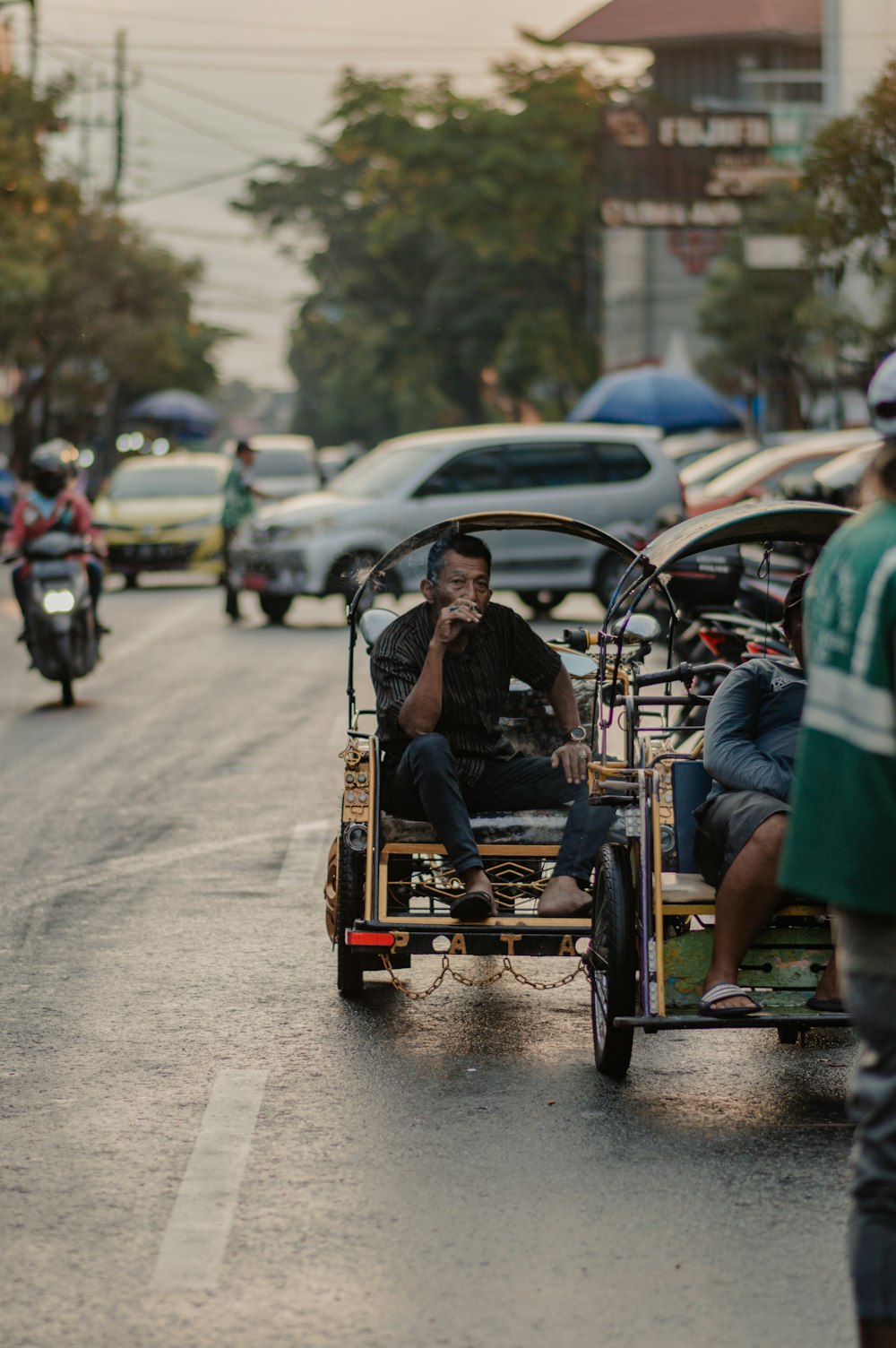 man in green shirt riding on brown wooden cart