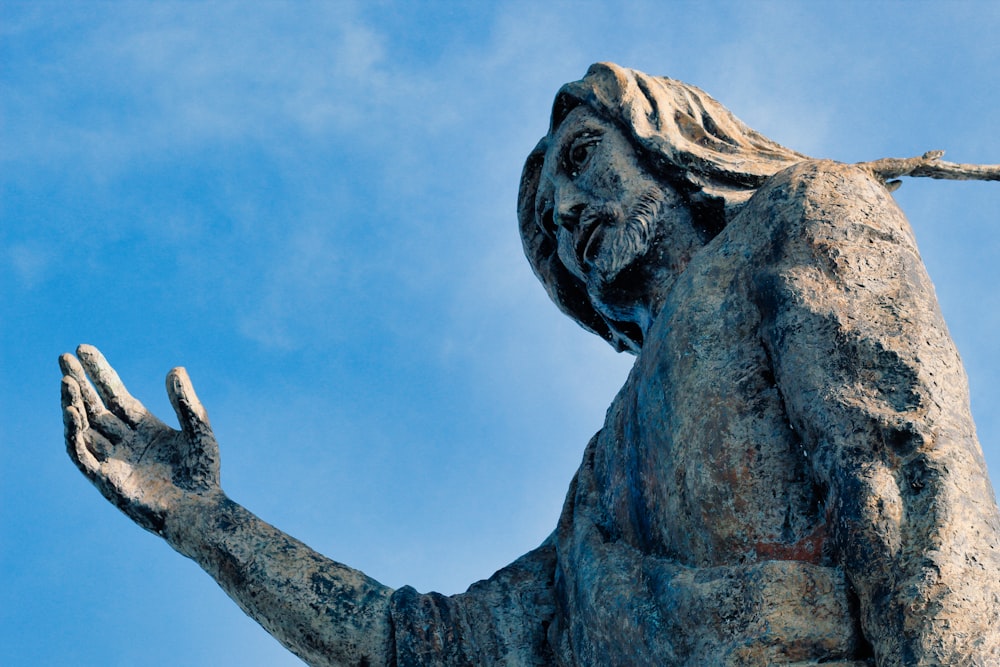 man in black shirt statue under blue sky during daytime