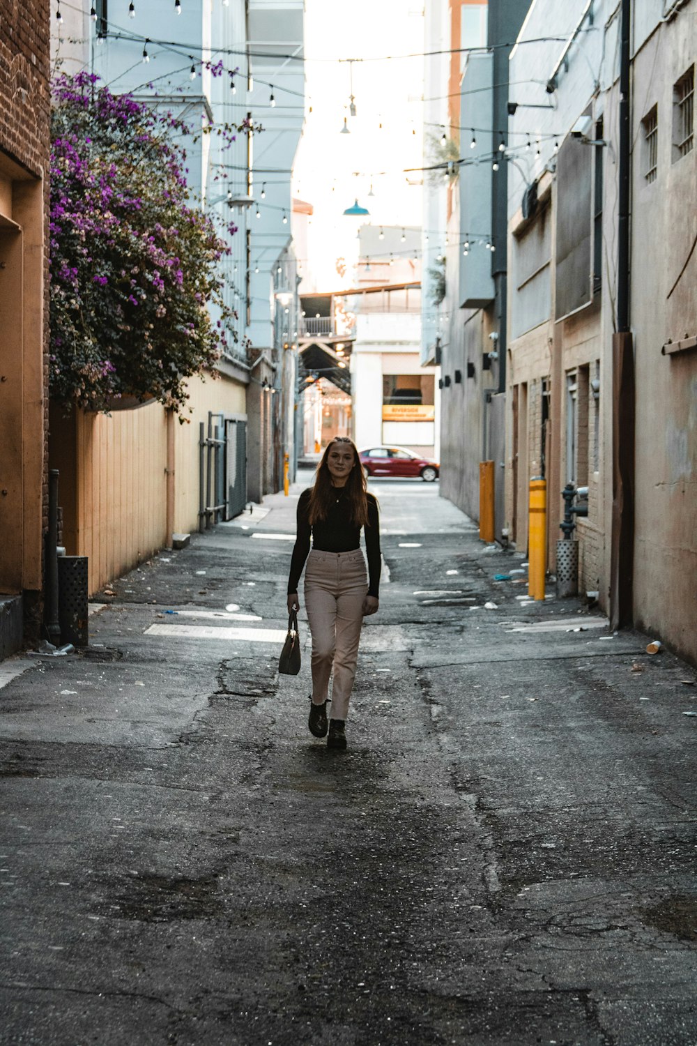 woman in black jacket walking on sidewalk during daytime