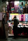 man in gray hoodie standing in front of store