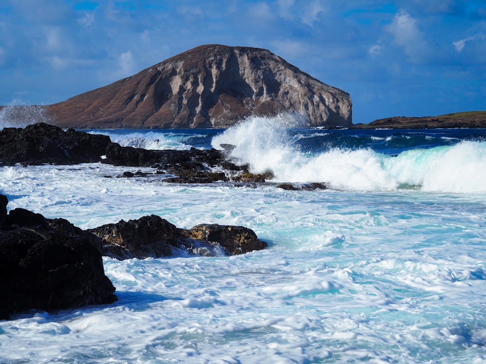 ocean waves crashing on rocky shore during daytime