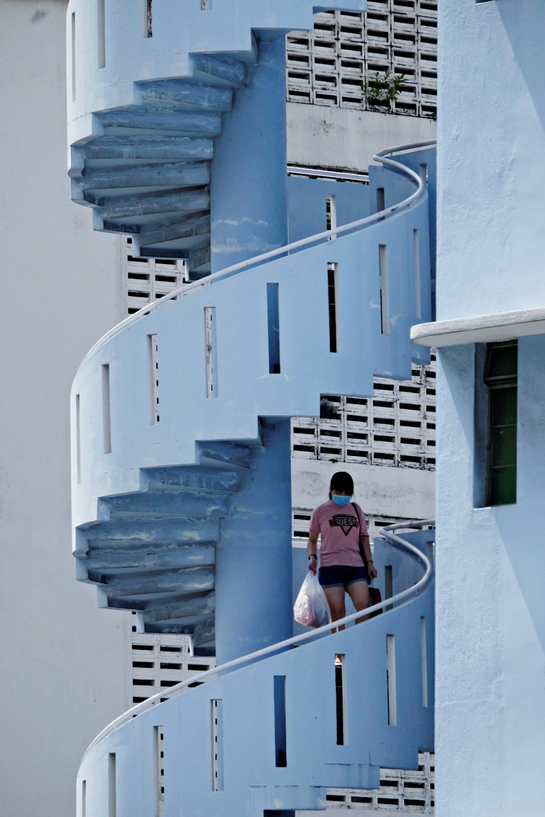 woman in red shirt standing on blue staircase