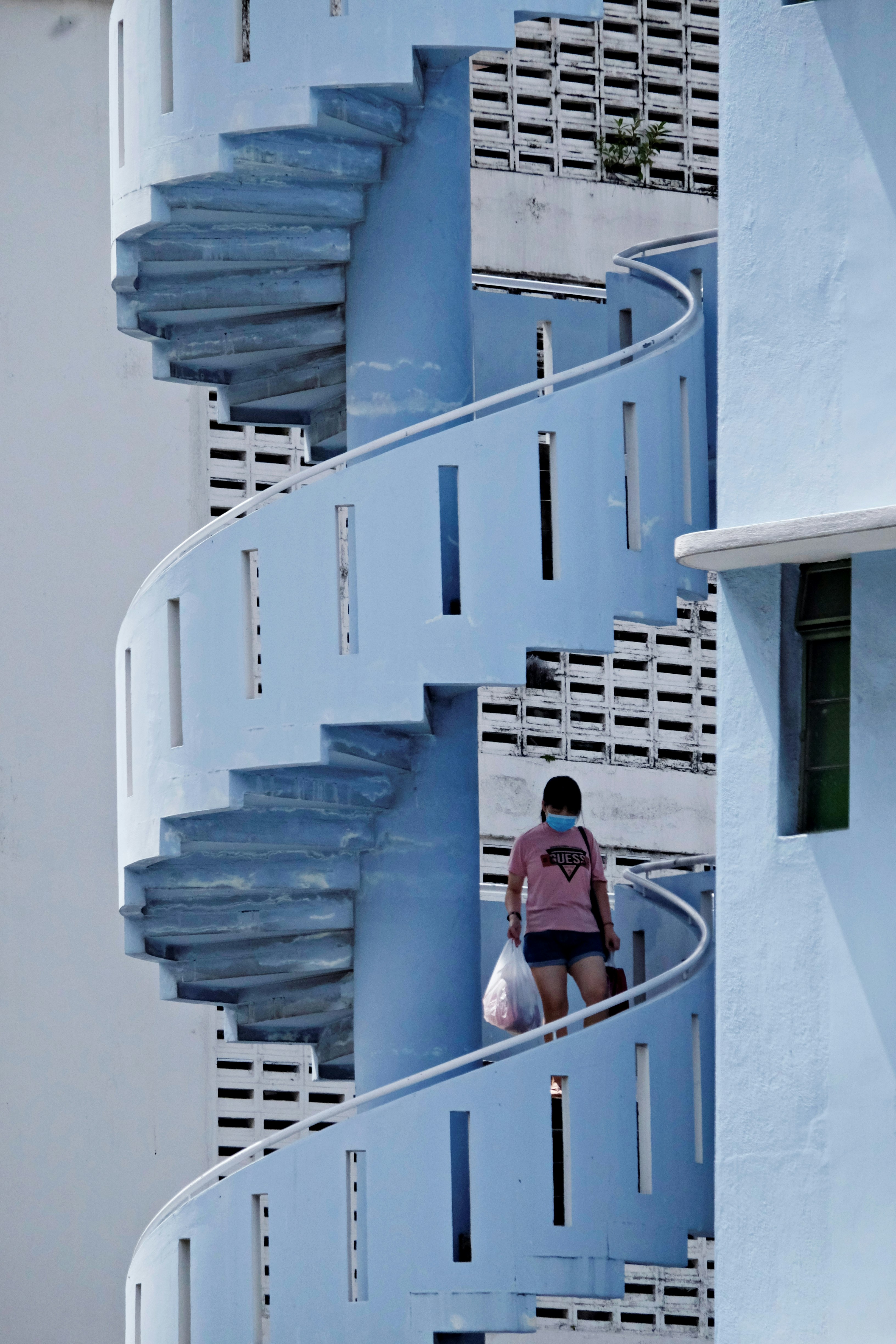woman in red shirt standing on blue staircase