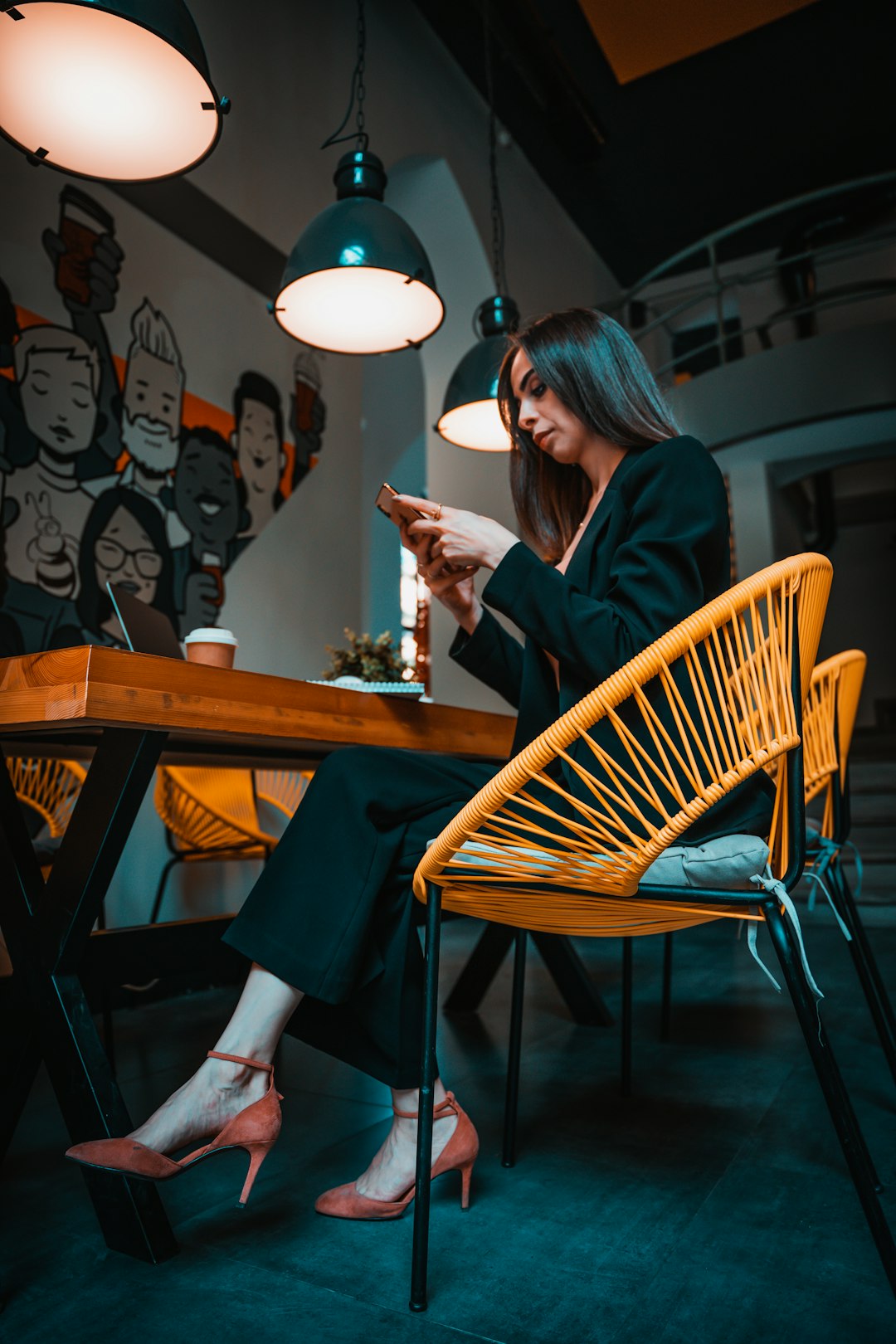 woman in black long sleeve shirt sitting on brown wooden chair