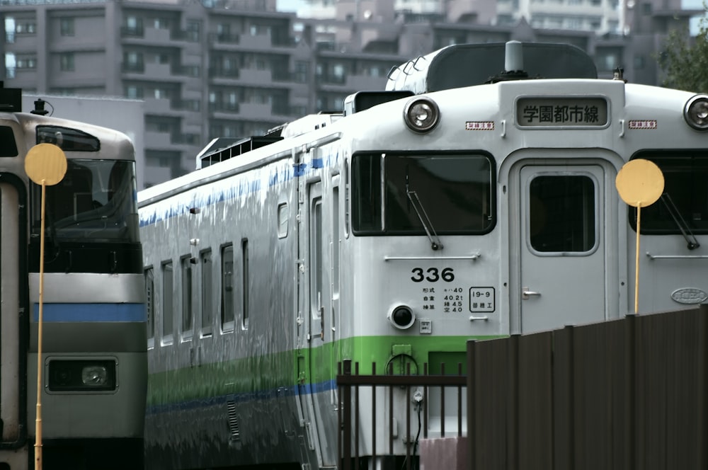 Tren blanco y verde en la vía férrea durante el día