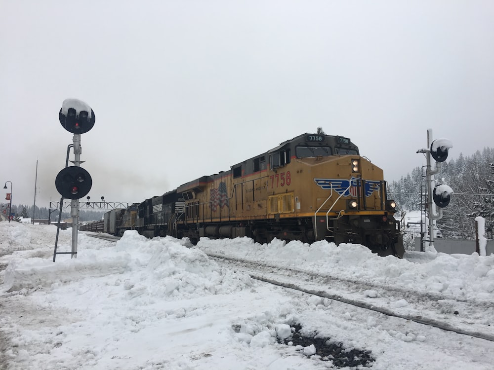 yellow train on rail tracks during daytime