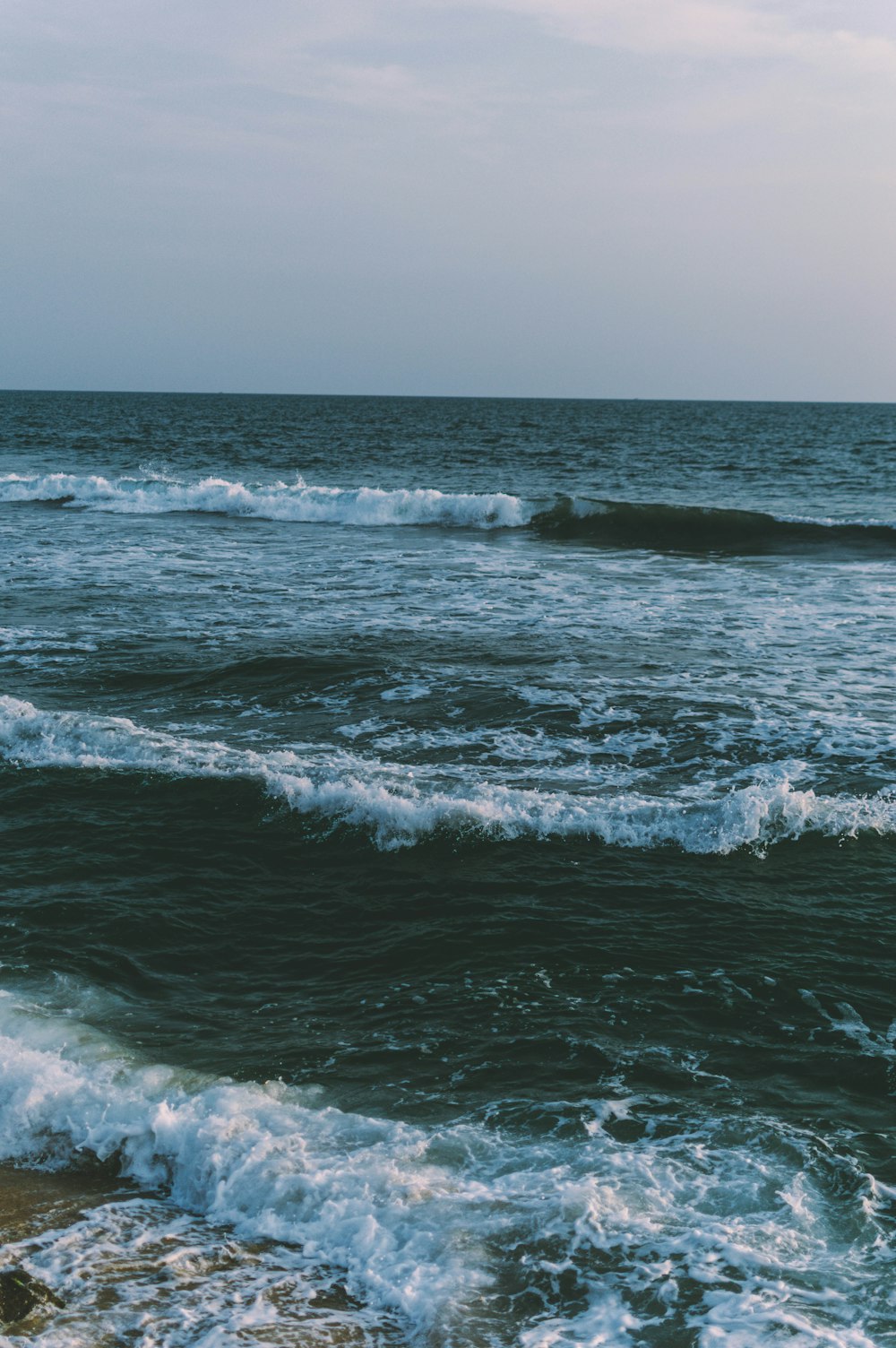 ocean waves crashing on shore during daytime