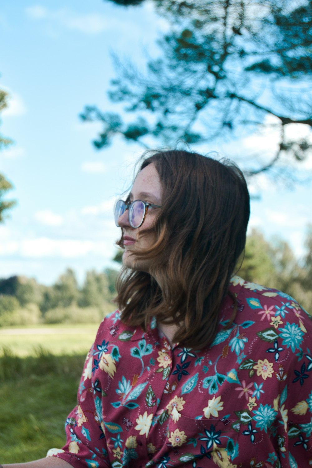 woman in red white and blue floral shirt wearing black framed eyeglasses