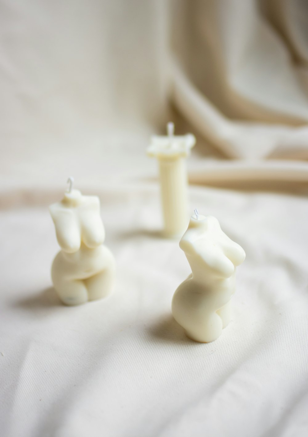 white candles on white textile