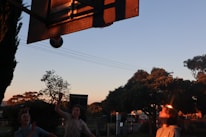 Children playing basketball in a green outdoor area at the rehabilitation center.