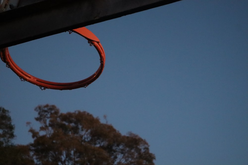 orange basketball hoop near green trees during daytime