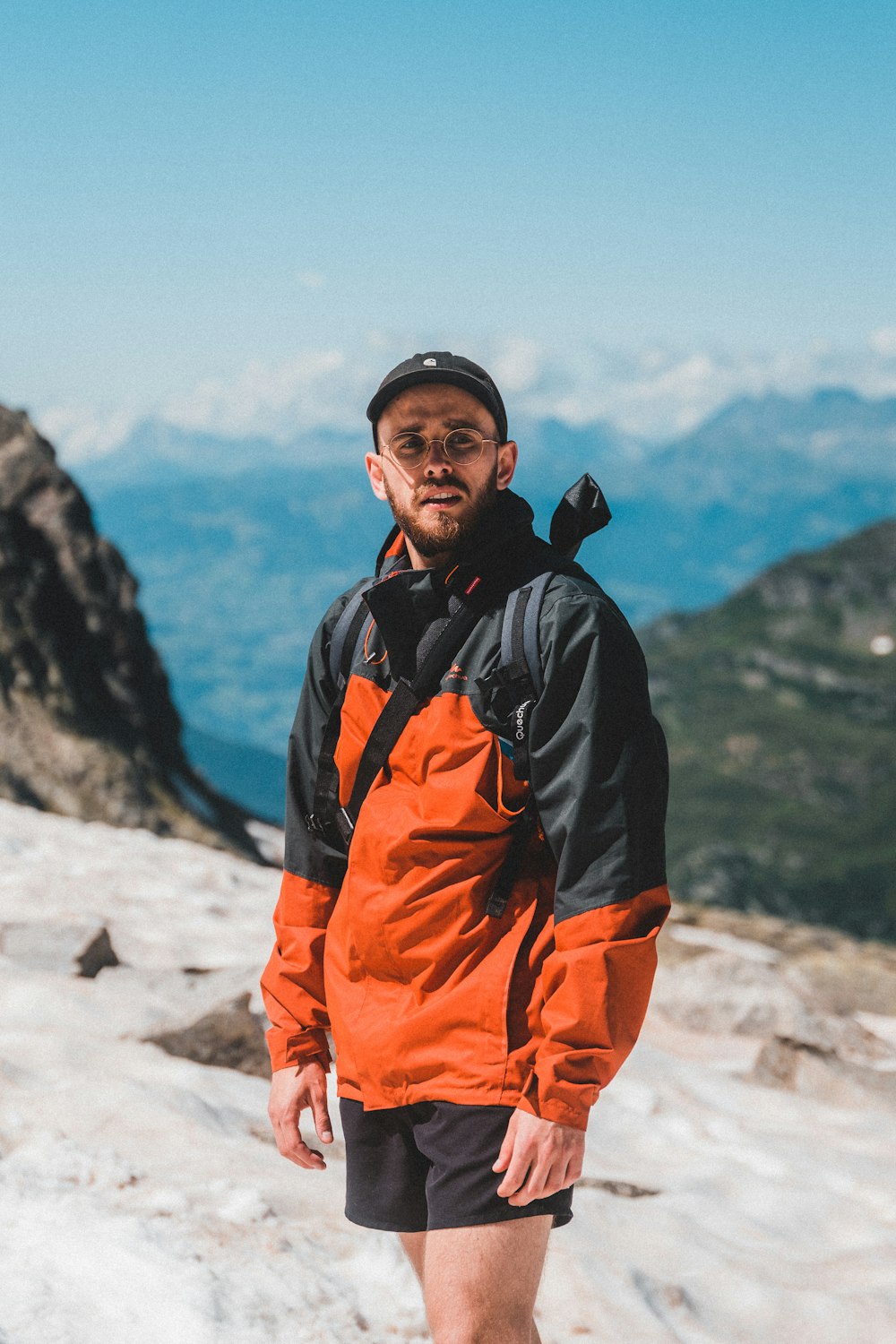 man in black and orange jacket wearing black cap