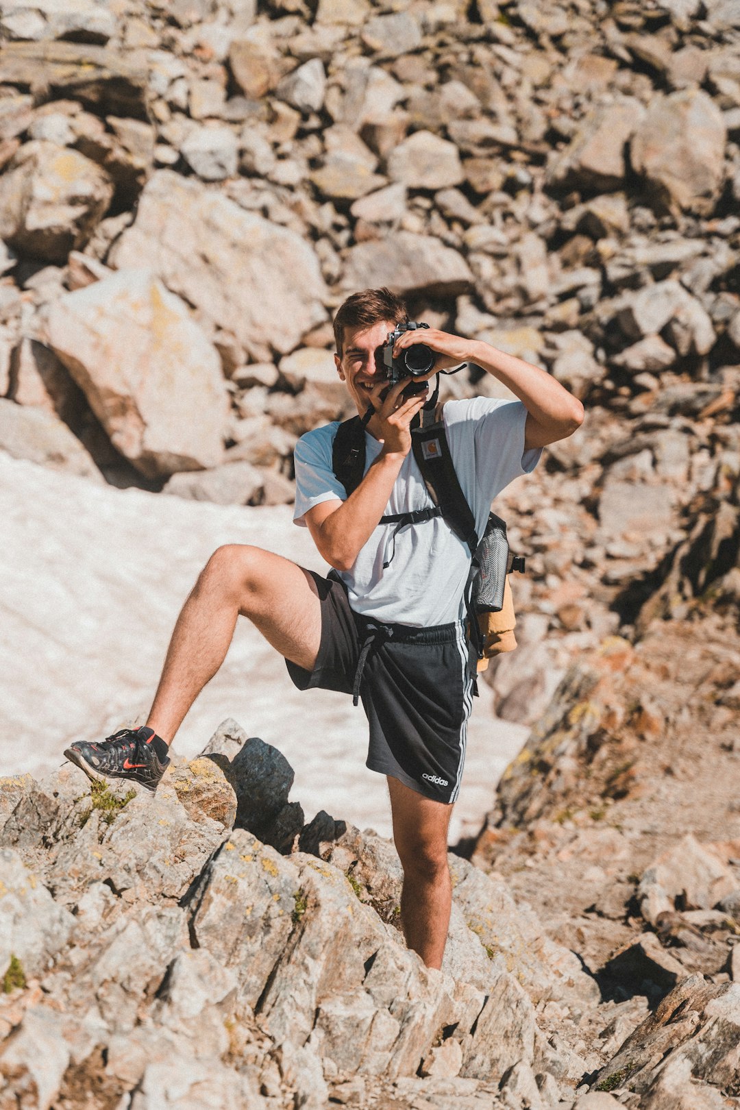 woman in grey shirt and black shorts with black dslr camera on her ear