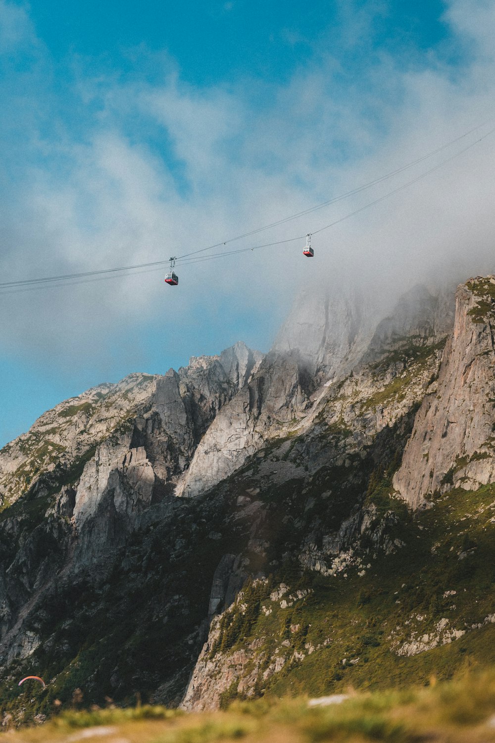 cable cars over rocky mountain during daytime