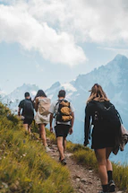 Family hiking together on a lush green Patagual valley trail with smiles and backpacks