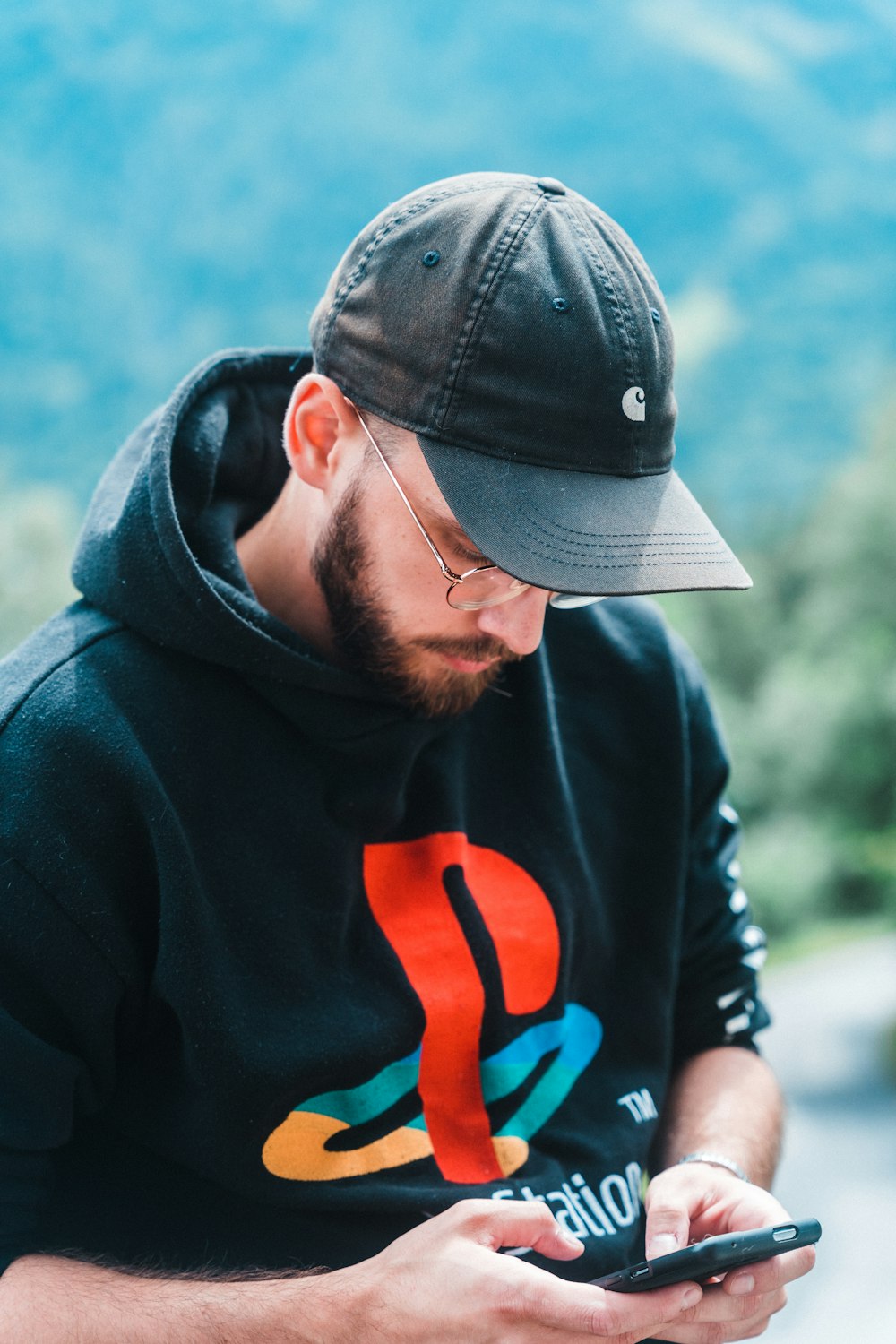 man in black and orange hoodie wearing black cap