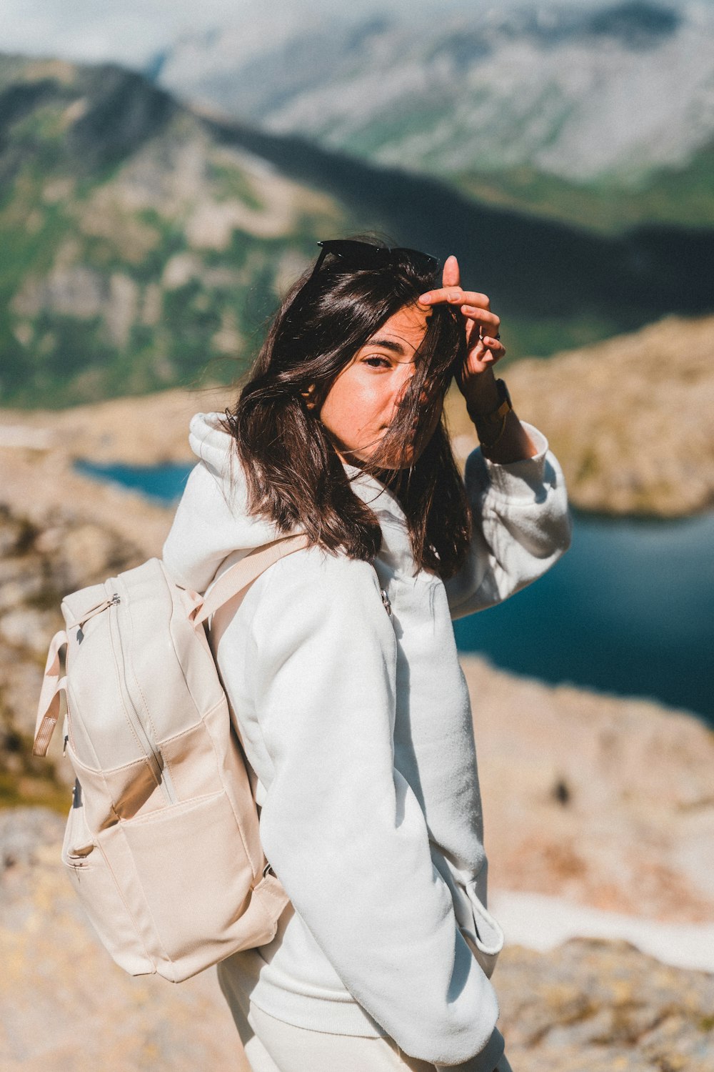 woman in white long sleeve shirt covering her face with her hair