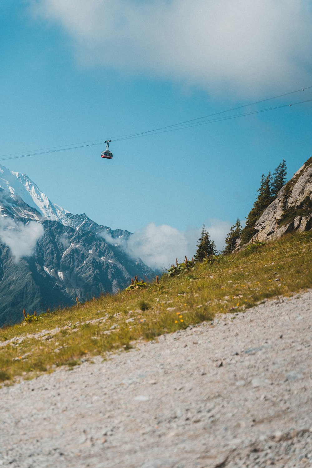 black cable car over green grass field near snow covered mountain during daytime