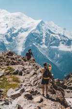 Trail runners navigating a rugged mountain path under clear blue skies.