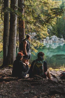 2 women sitting on rock near body of water during daytime