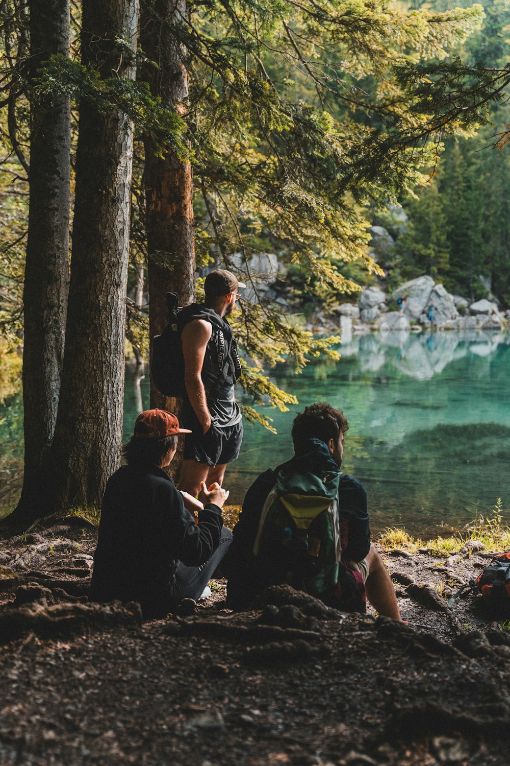 2 women sitting on rock near body of water during daytime