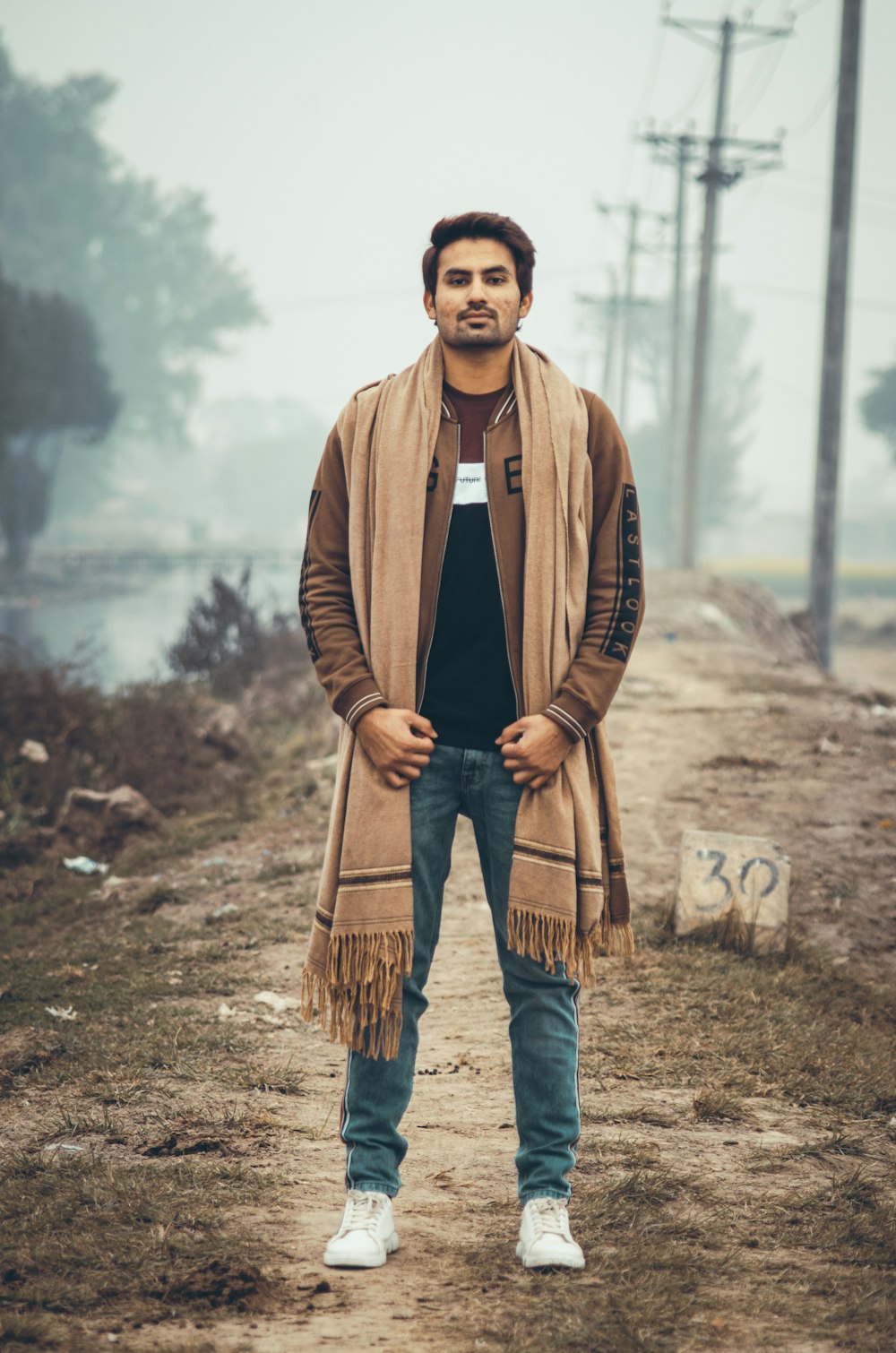 man in brown coat standing on brown field during daytime