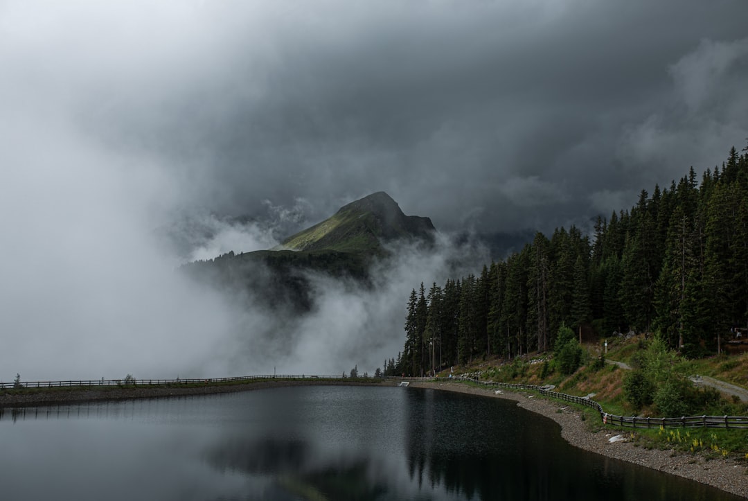 green mountain beside river under cloudy sky during daytime