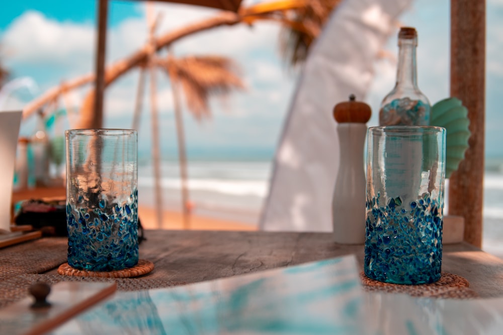 clear glass bottle beside clear glass jar on brown wooden table