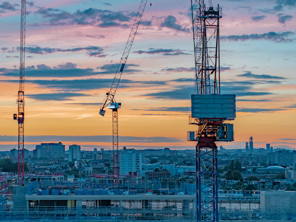 blue and white crane under cloudy sky during daytime